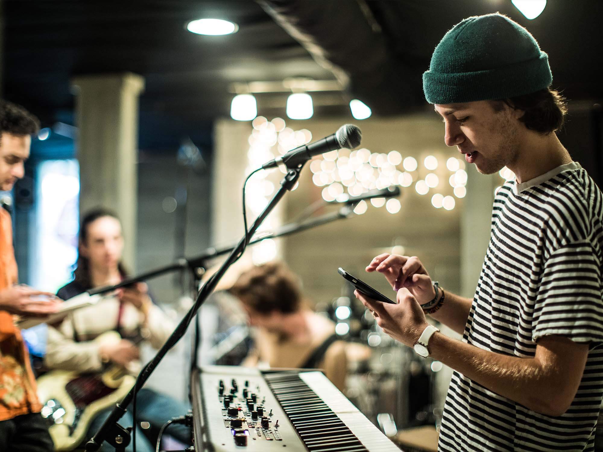 Keyboard player uses mobile phone at band practice