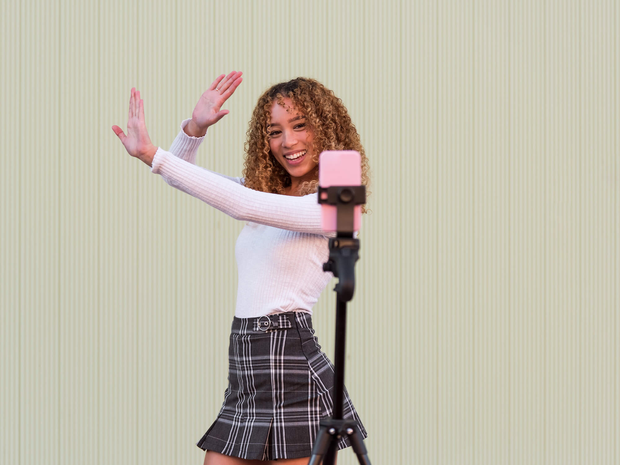 A young woman dancing in front of a phone on a tripod