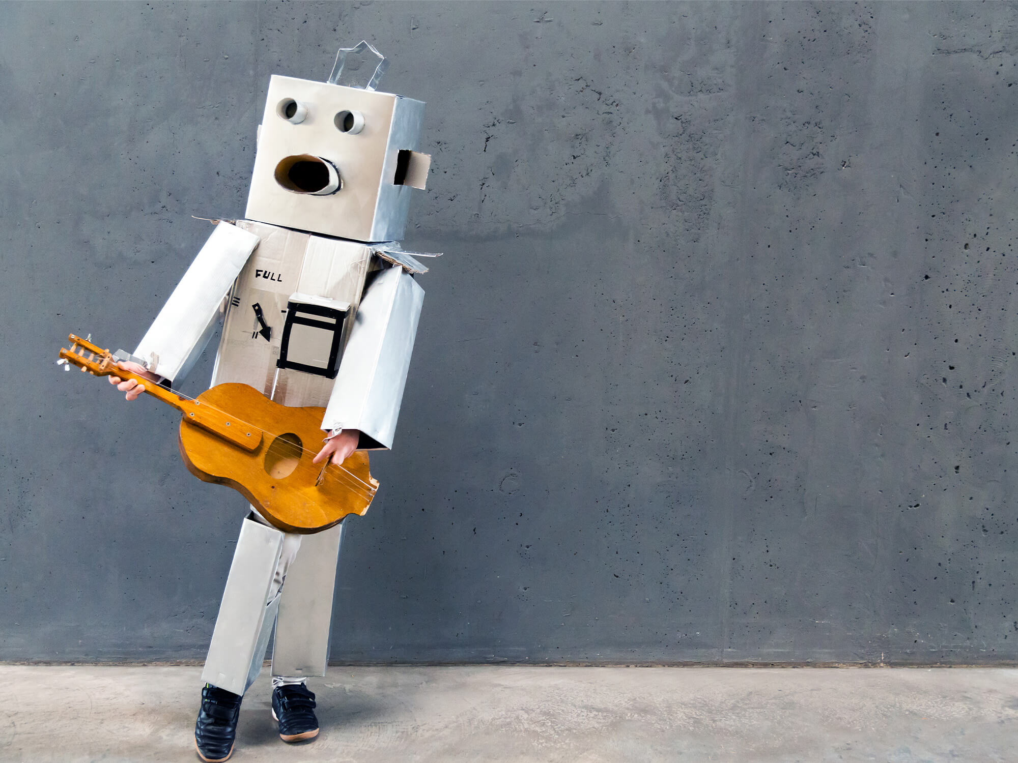 A small grey robot holding a guitar