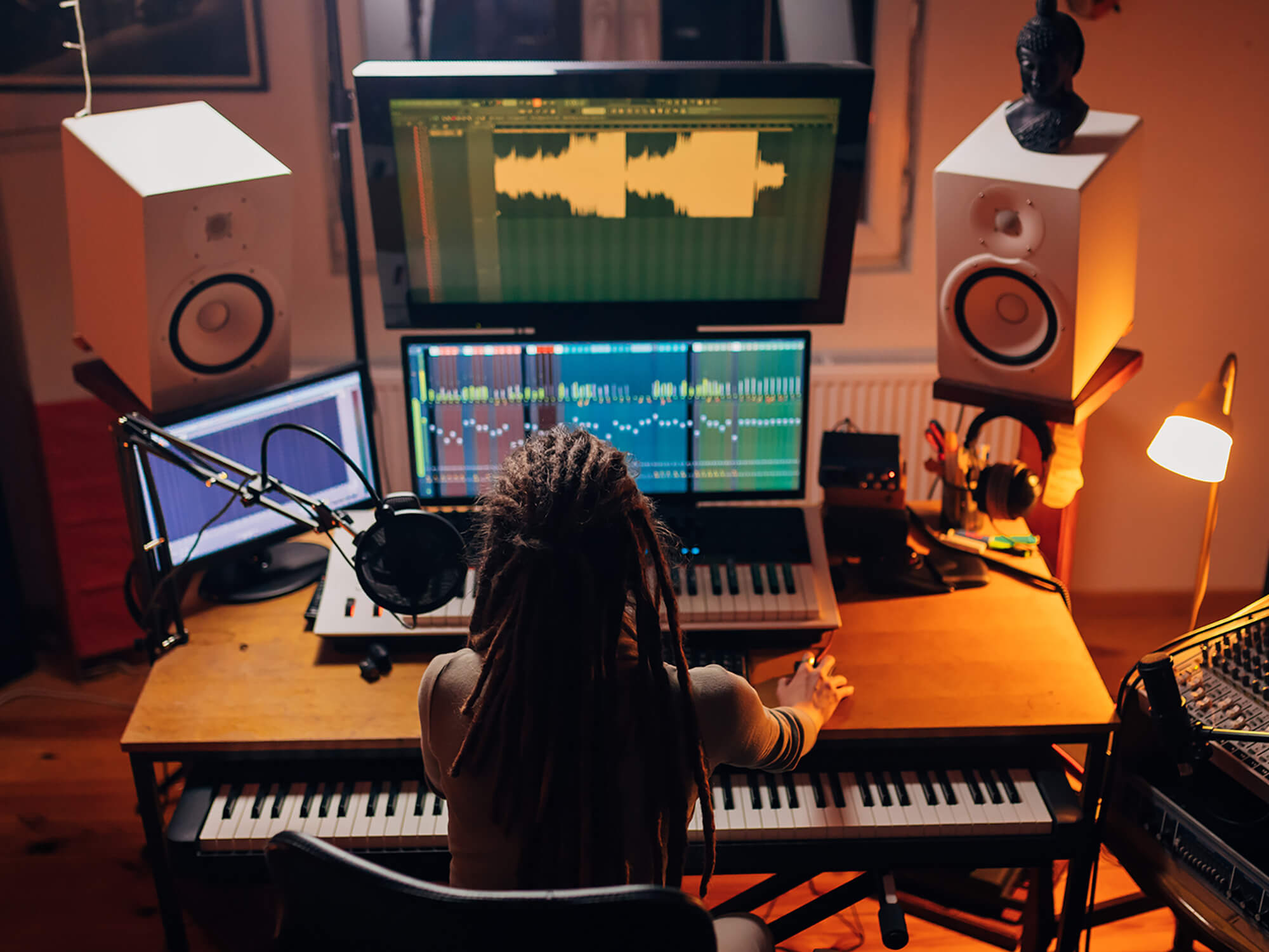 Producer working on music in home studio, photo by Kosamtu via Getty Images