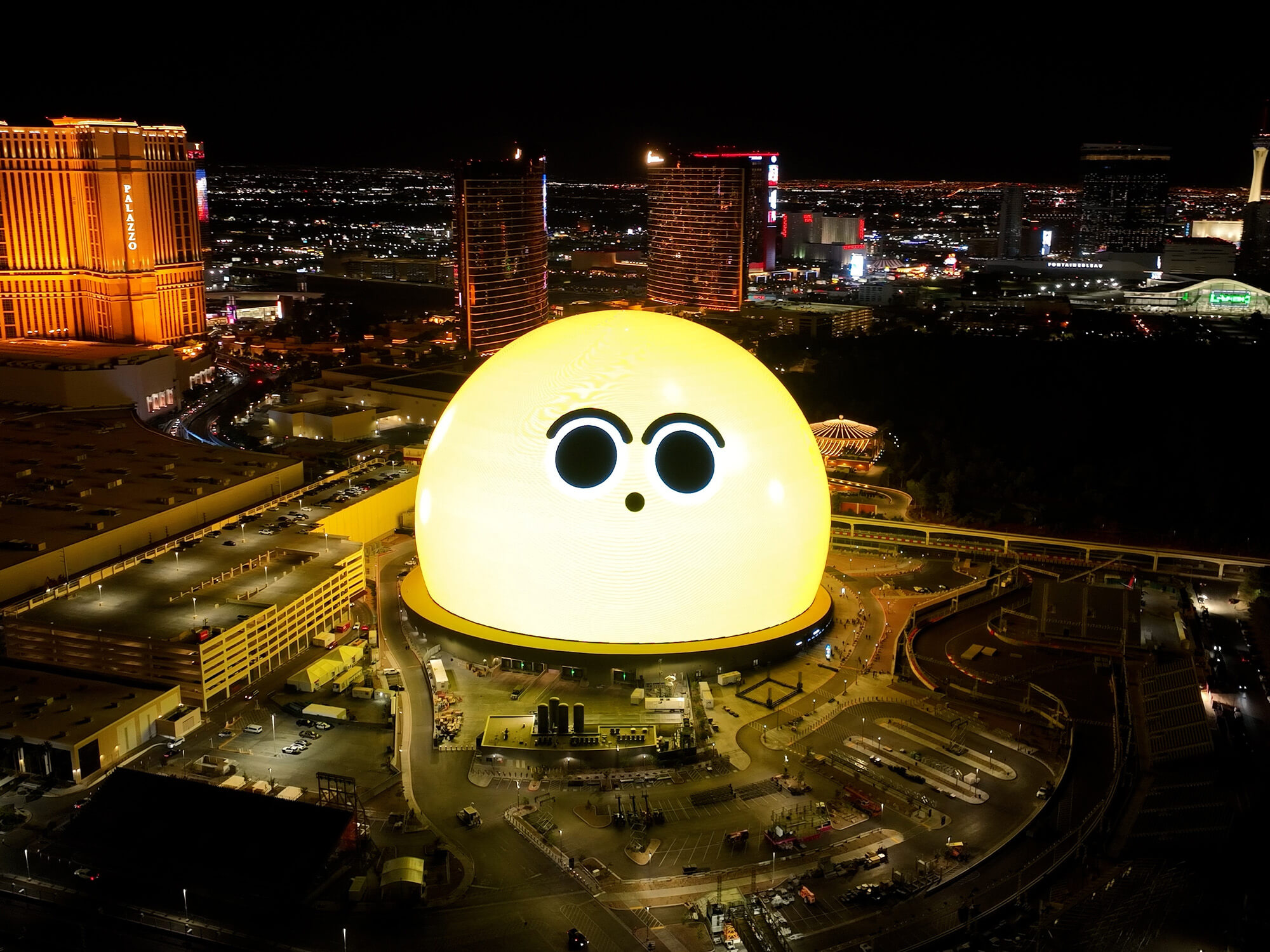 The Sphere photographed from above. It is showing a yellow animated face on its surface. Its expression is surprised.