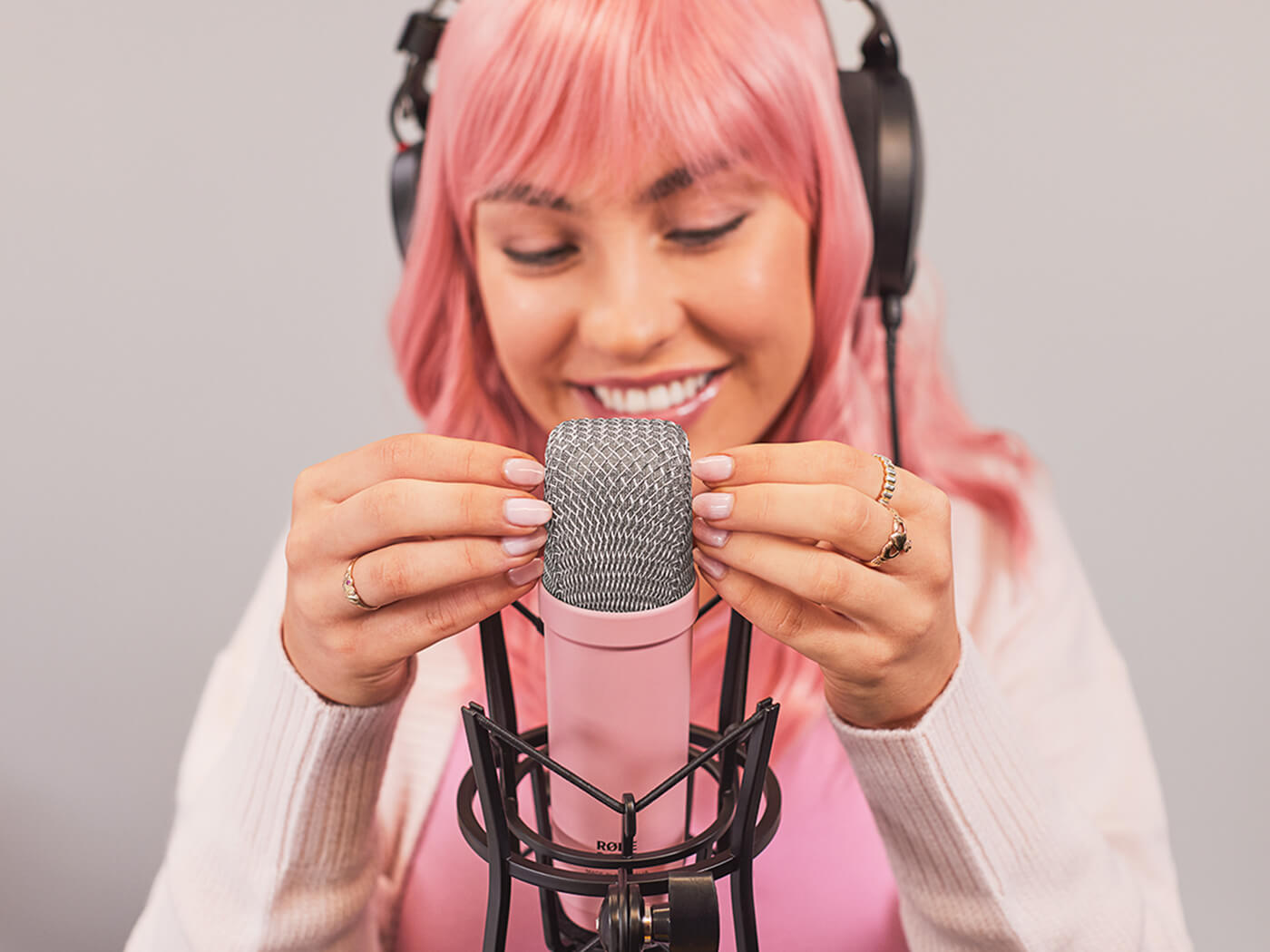 ASMR artist tapping their fingernails on a RØDE NT1 Signature Series condenser microphone in pink