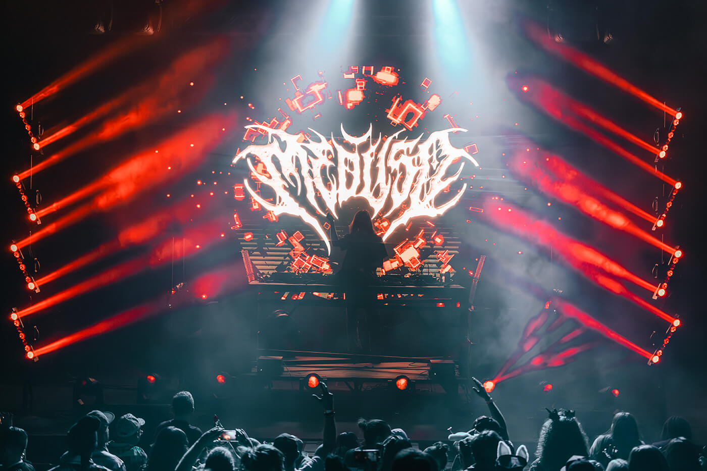 Meduso performing live against a backdrop of metal-inspired visuals