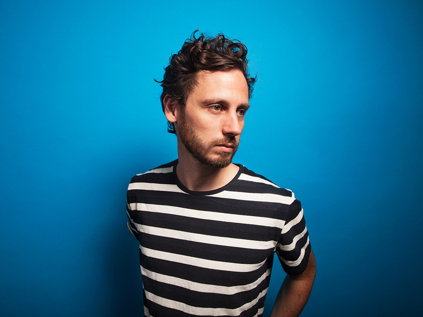 Mason photographed in a black and white striped T-shirt against a blue background, photo by Mason