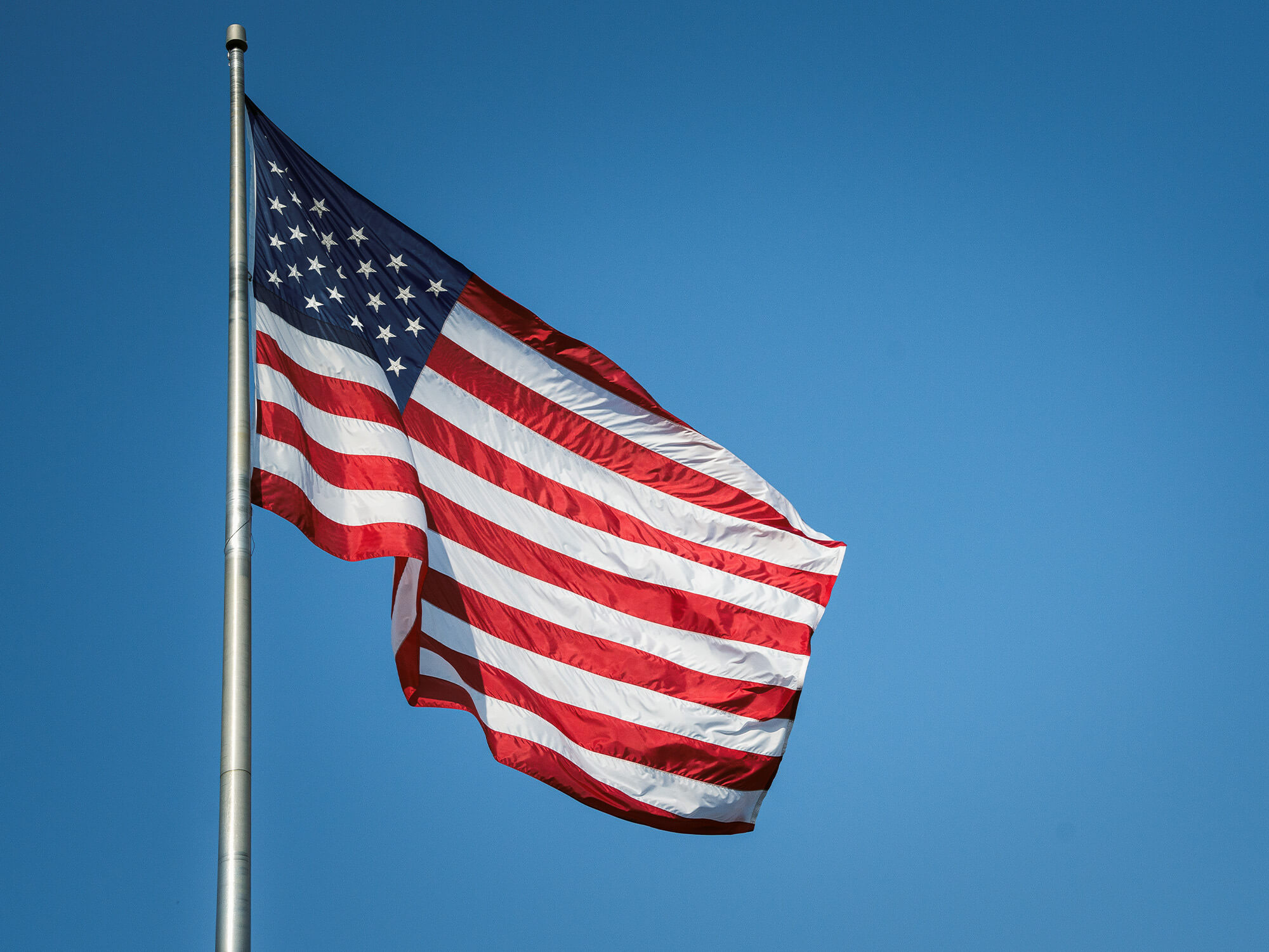 American flag on a flag pole among a blue sky