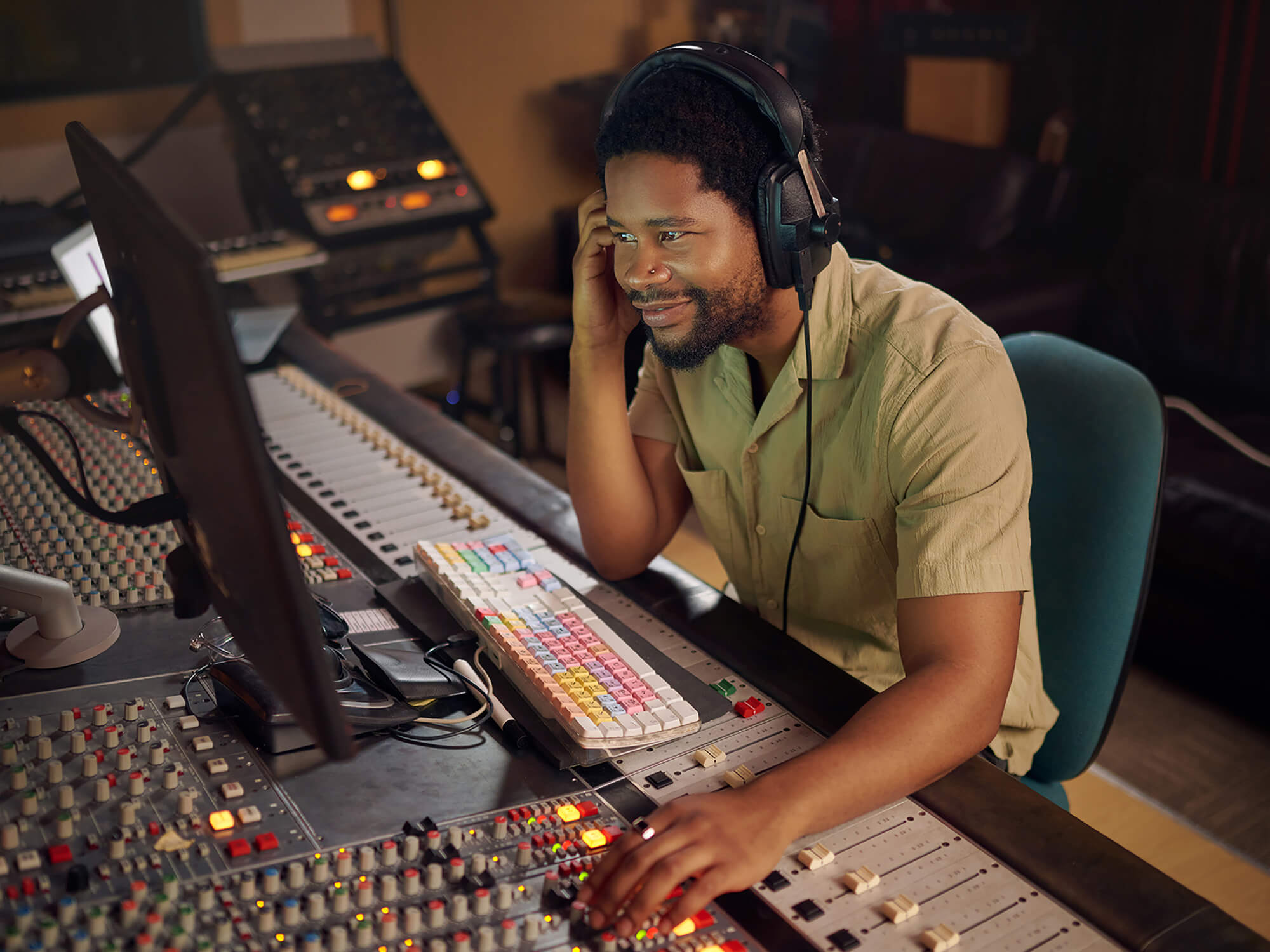 Music producer at a work desk in a studio, photo by PeopleImages via Getty Images