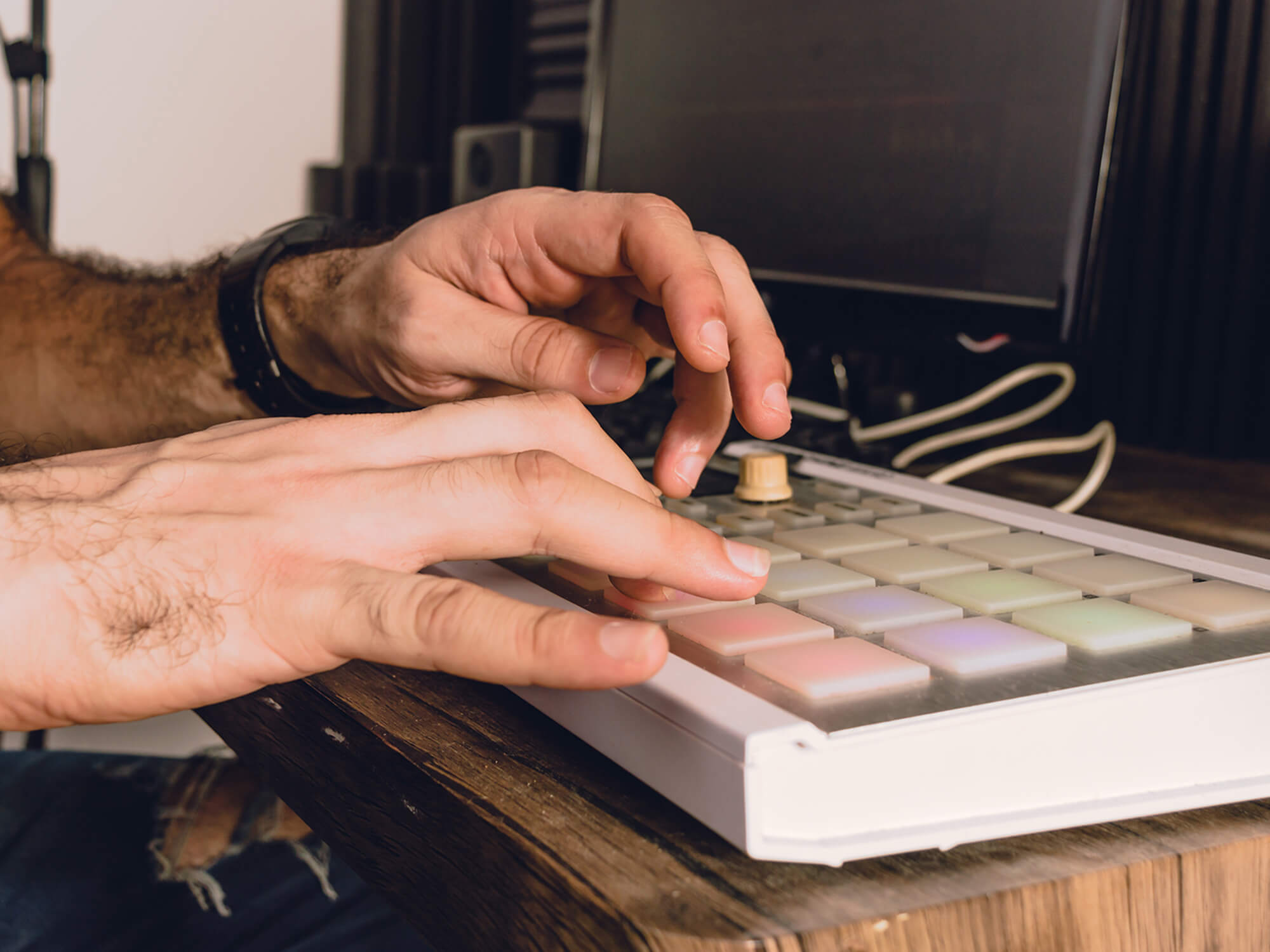 Hands on a MIDI controller in a home studio, photo by Jose Contreras/Getty Images